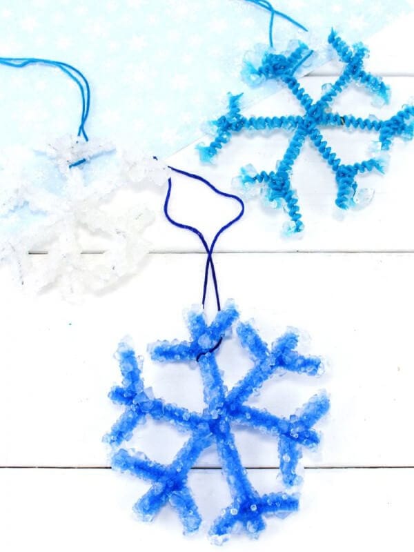 Sparkly blue and white snowflake ornaments with a white backdrop