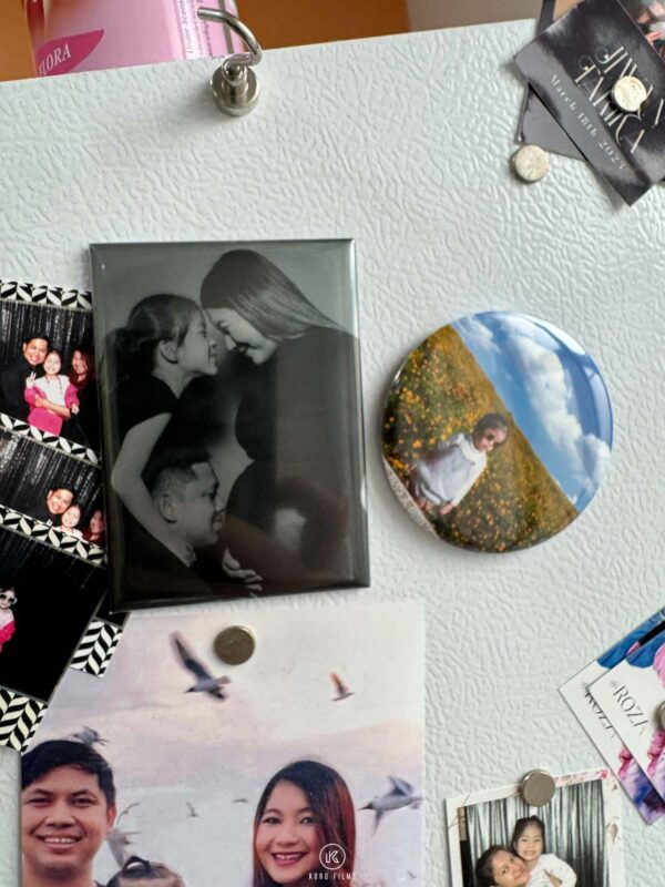 Black-and-white rectangular photo magnet and a round photo magnet on a fridge door