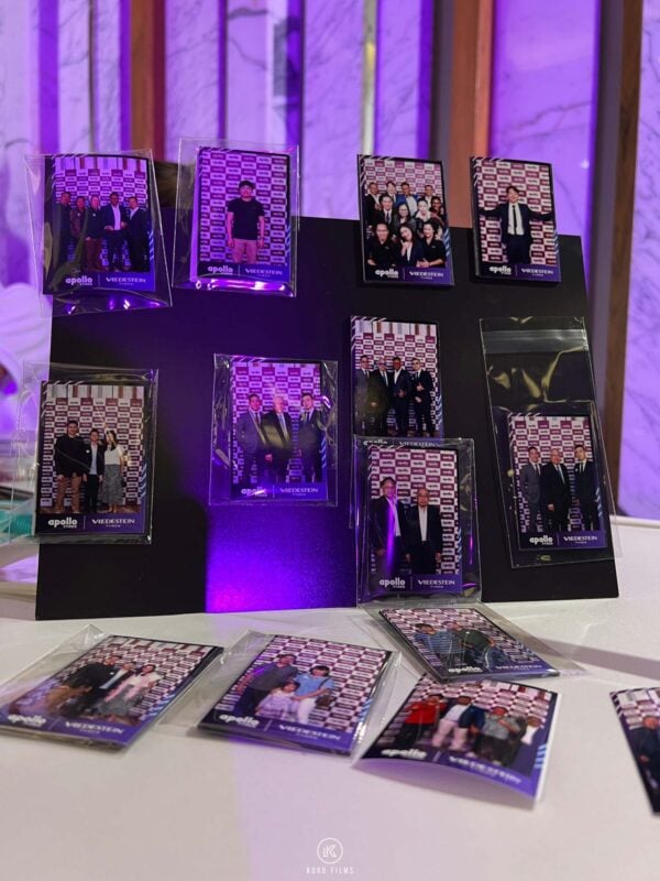 Guests' photo magnets in clear sleeves displayed on a stand at a corporate event