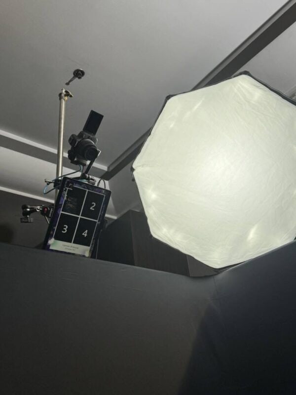 Overhead DSLR camera, screen and softbox light mounted above a top view photo booth