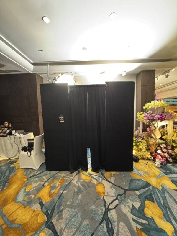 Top view photo booth set up in a hotel ballroom with a black curtain and overhead light