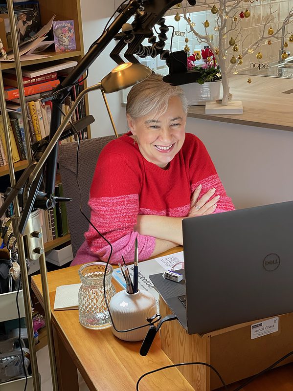 Lisa sitting at a desk with a laptop.