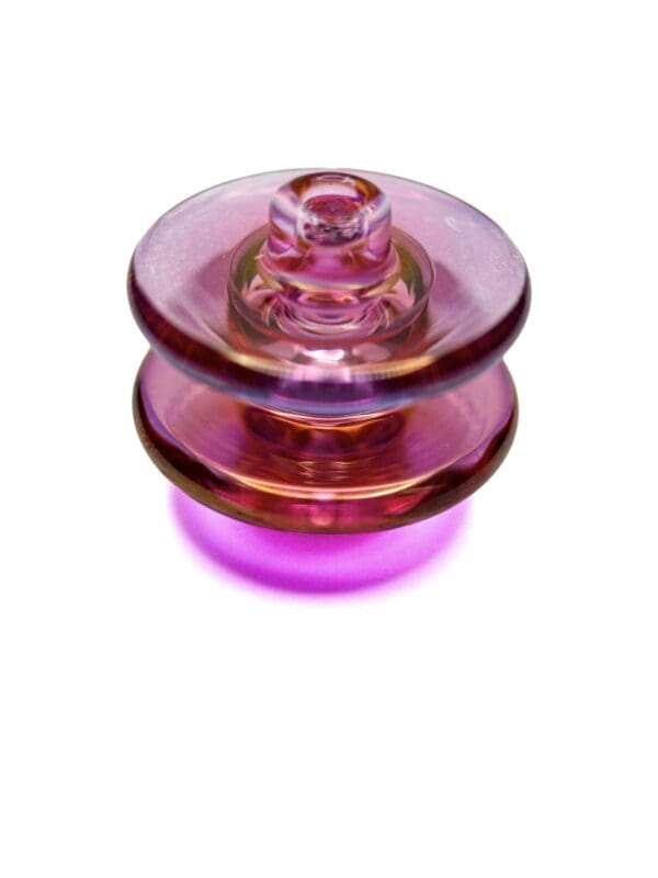 Opalescent pink iridescent carb cap made from glass for use with compatible quartz bangers.