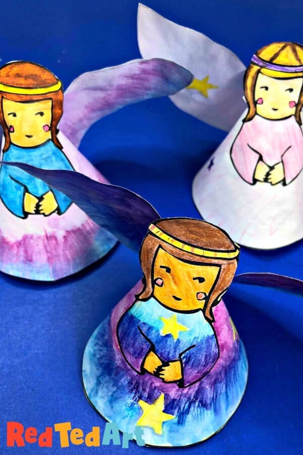 paper angels craft made with printable on a blue backdrop