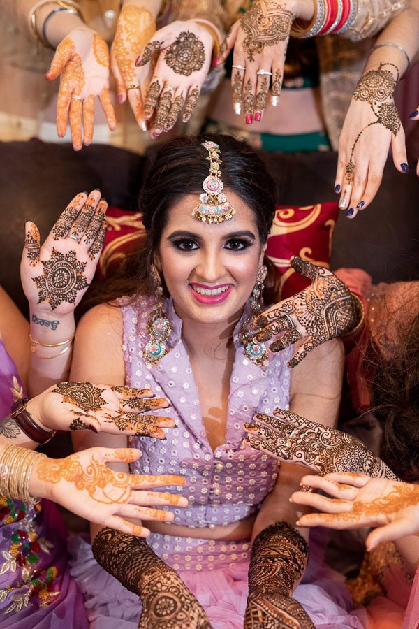 Bride smiling as she shows her henna at her Mehndi