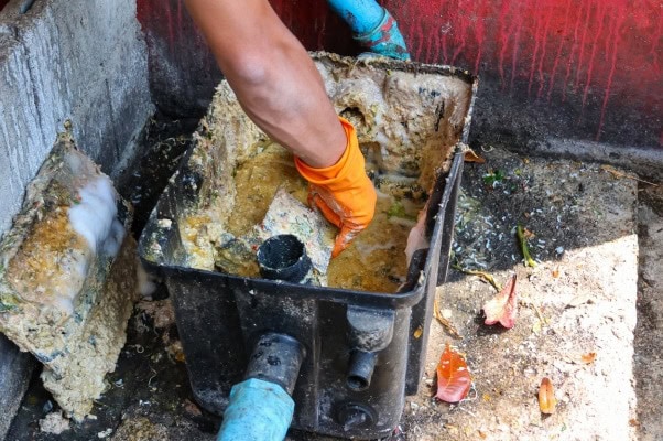 Technician cleaning restaurant grease trap