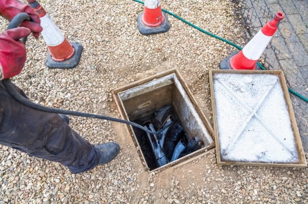 Technician using drain snake during emergency callout