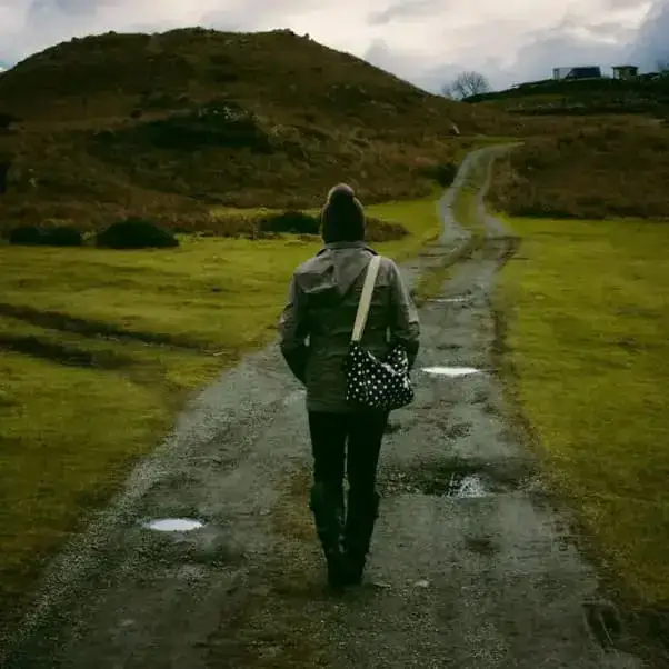 Eine Person geht einen ländlichen Weg entlang, passend zum Thema Gesundheit und Bewegung.