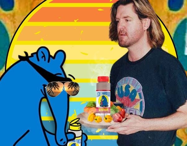 Secret Aardvark Founder Scott Moritz with the Aardvark (wearing sunglasses) in front of a bright, tropical-themed background.