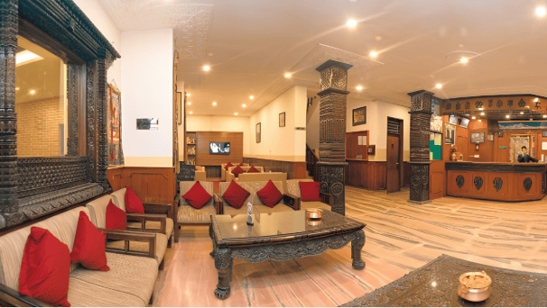 Traditional wooden carved empty lobby reception desk and lounge area inside a boutique hotel. The visual reflects hotel occupancy trends and customer volume in premium lodging establishments.