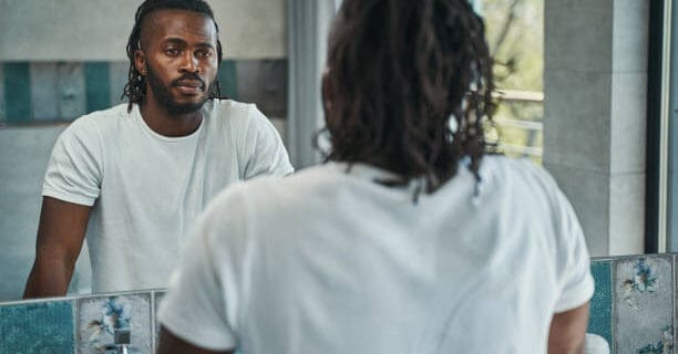 Reflective therapist conducting a counseling session with diverse client in a modern therapy office.