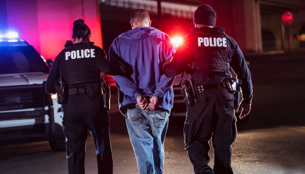 Police officers arresting a man for alcohol-related offense – legal issues and ETG test relevance.