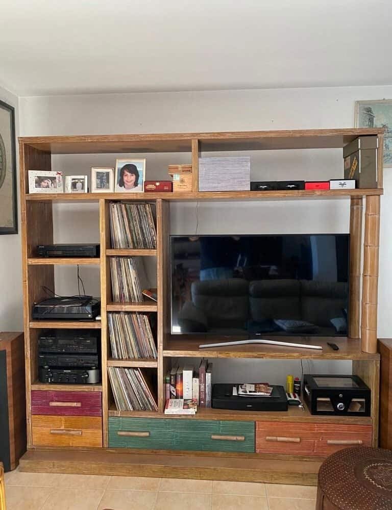 Alt: Libreria in legno con TV, vinili e memorie, stile vintage, arredo soggiorno moderno.