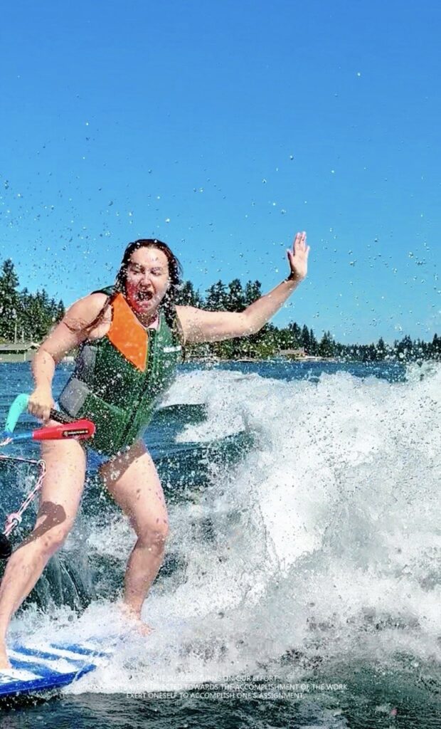 Smiling rider waving while wakesurfing in Seattle