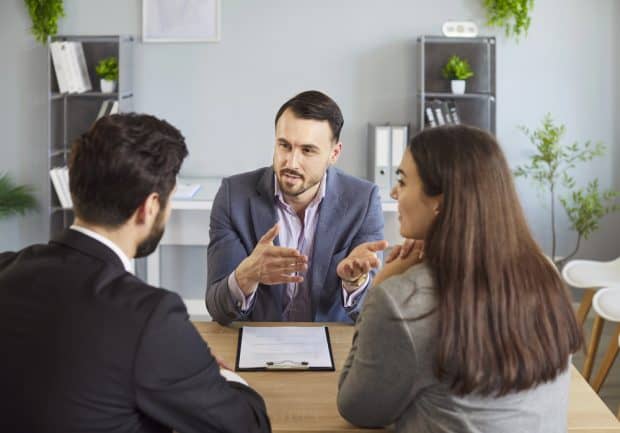 image of couple meeting with lawyer for a post about 10 reasons why aspiring franchisees need a franchise attorney