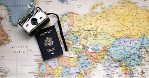 United States Passport and a vintage camera on a world map