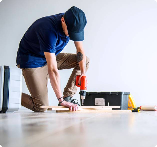 Tischler bei der Montage von Holzelementen mit Akkuschrauber