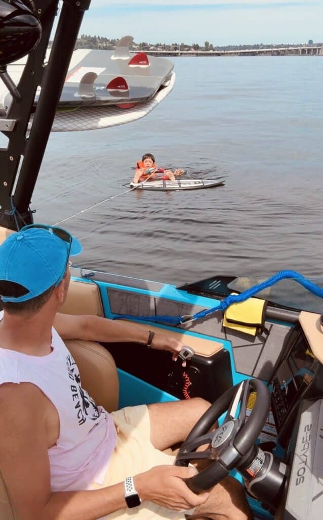 Guests on the SurfWhisperer boat watching a wakesurfer on the lake