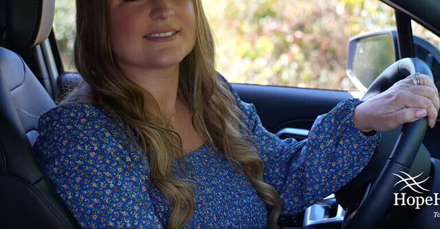 Female nurse practitioner smiling in car