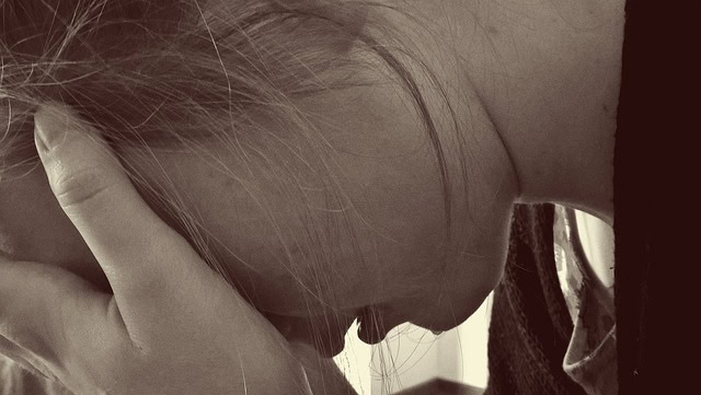 Heartbreak: at World's End! - Woman sits crying with her head in her hands - symbolises the pain of separation, coping with heartache and the emotional pain after a break-up