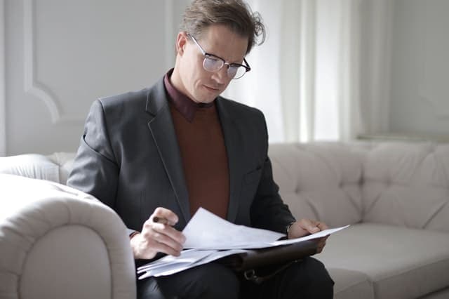 Classy Executive Male Reading Papers On Couch 3760514 - Auster Inteligência Contábil