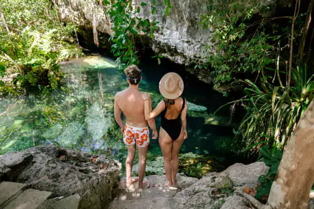 pareja posando en la belleza de un cenote de mexico