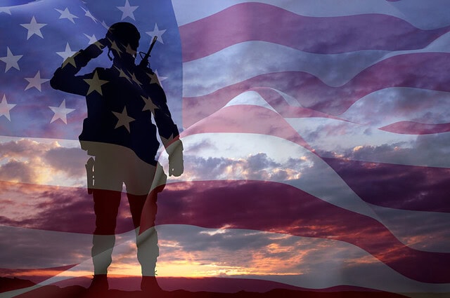 Silhouette of a soldier with USA flag against the sunset