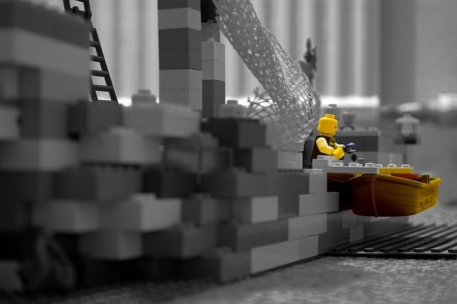 LEGO construction scene with worker minifigure and building elements.