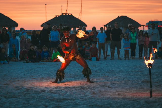 Hombre bailando danza de fuego en la playa durante un festival en Samoa