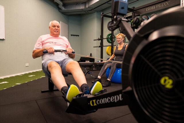 Klant op roeiapparaat in trainingszaal van Fysiotherapie Dunant