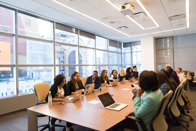 A group of colleagues having a meeting in a large room.