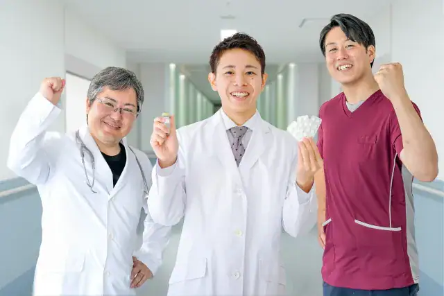 ガッツポーズをする医者三人