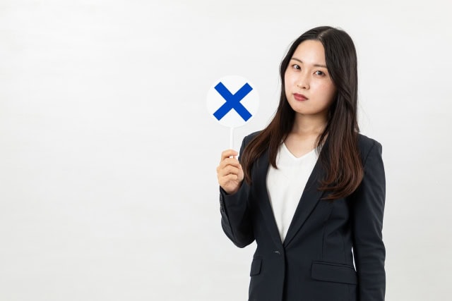✖サインを出す社会人女性
