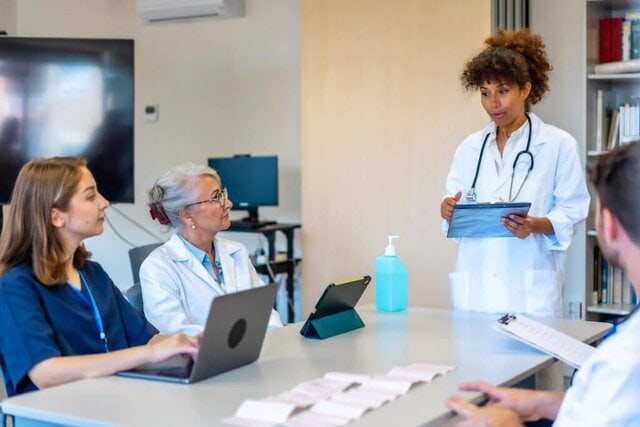 Healthcare provider reviewing digital marketing analytics on a computer with patient-focused website on screen