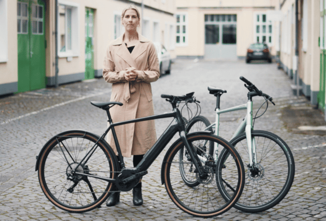 Cannondale Quick Neo SL 2 e-bike, standing next to a rider in an urban setting, highlighting its streamlined design and integrated motor.