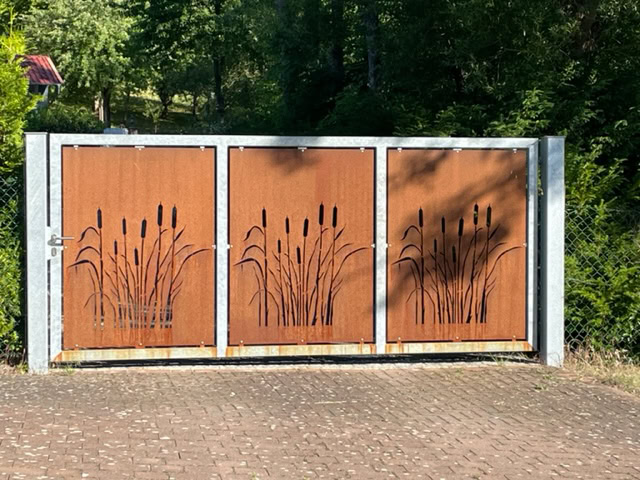 Dekoratives dreiteiliges Gartentor in Cortenstahl-Optik mit gelaserten Rohrkolben-Motiven, ein Produkt von Tore & Torsysteme von Stahl- und Metallbau Drost.