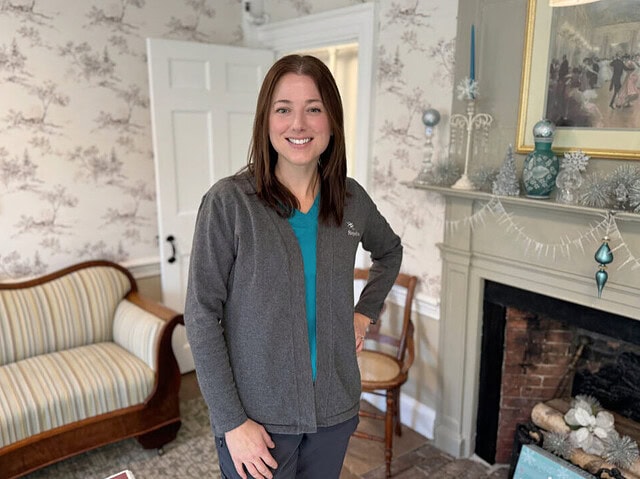 Nurse smiling in a room with a fireplace