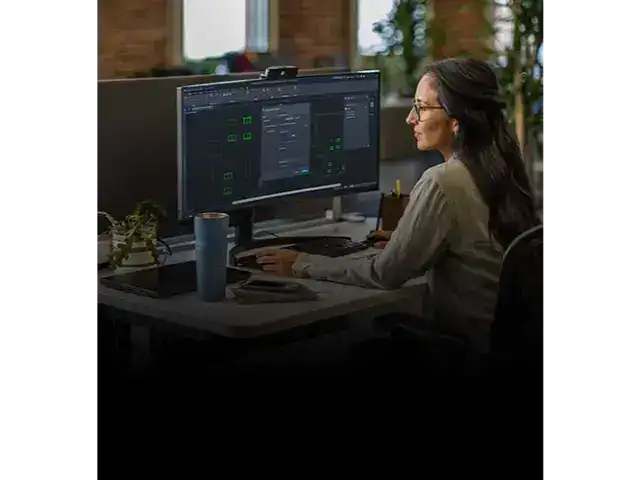 Operatoare utilizând software-ul AutoCAD 2026 pentru monitorizarea și automatizarea proiectelor 3D pe un monitor