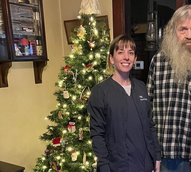 Man standing with nurse in front of Christmas tree