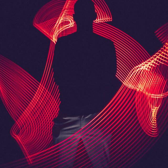 A shadowy figure in a room full of long exposure red light