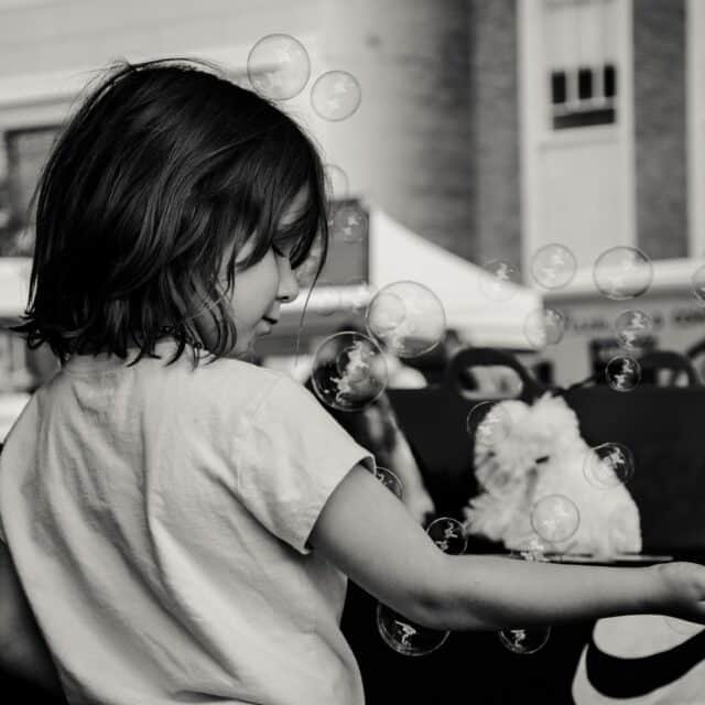 Play Therapy Image: Black and white image of child playing with bubbles