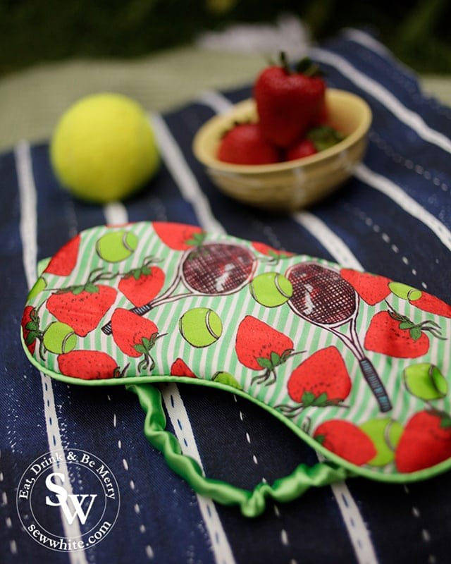 Silk eye mask from Caroline Randell in Wimbledon Village decorated with illustrations of tennis rackets, strawberries and tennis balls 