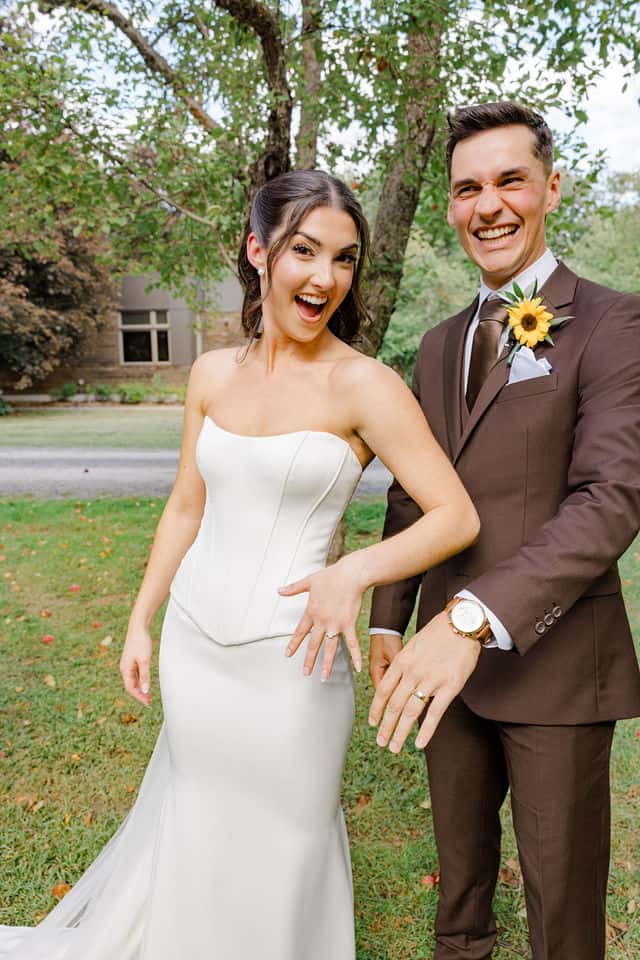 Julia and Will laughing and showing off their wedding rings just after the ceremony
