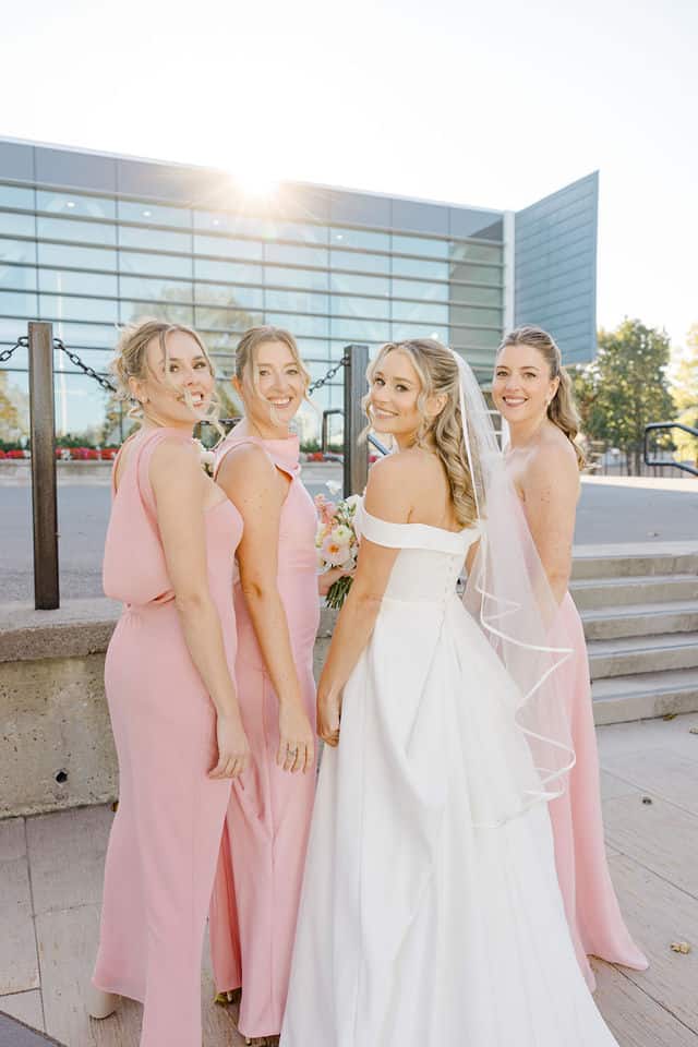 Bride and bridesmaids laughing together outside Lago on a sunny afternoon