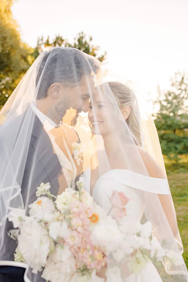 Bride and groom nose to nose under her veil in golden light for their fall wedding at Lago
