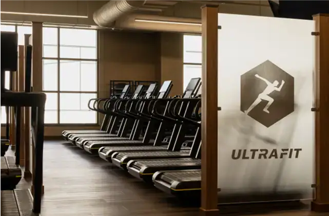 Modern fitness center featuring rows of treadmills, premium cardio equipment, and a dedicated workout area designed for residents in a luxury apartment community.