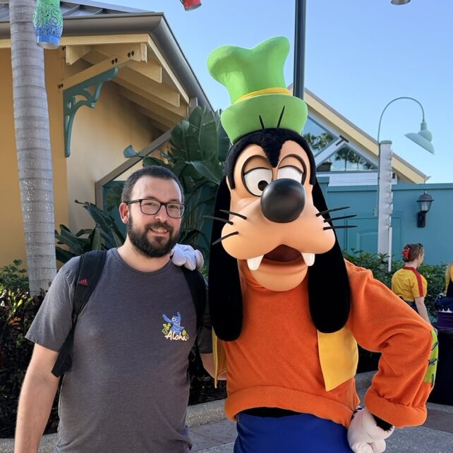 Playful interaction with Pluto in a vibrant outdoor setting at 407 Vacations. Perfect for family Disney vacations and theme park trips.