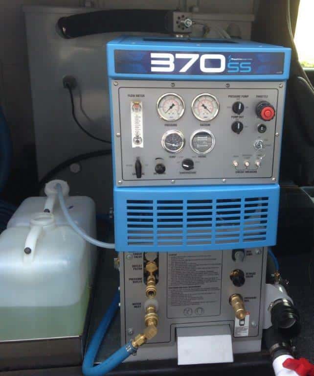 High-pressure carpet cleaning machine with gauges and hoses in a Lake Geneva home.