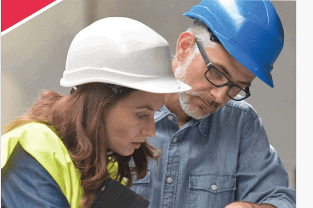 Zwei Bauarbeiter mit Schutzhelmen bei einer Besprechung auf der Baustelle in Karlsruhe.
