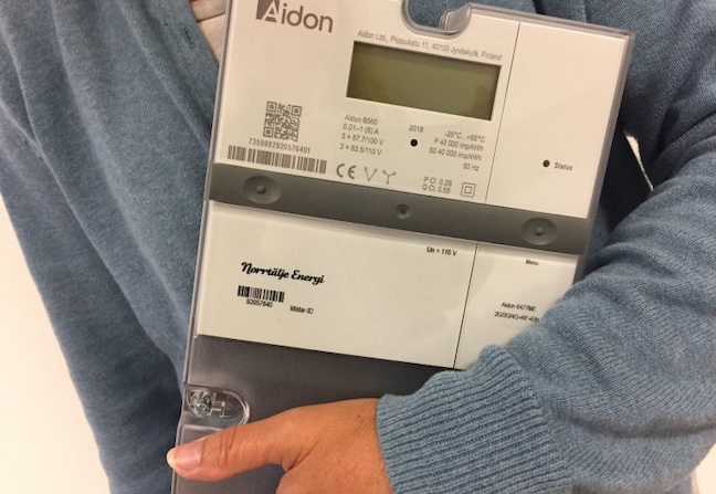 Elmätare av märket Aidon med digital display. Person håller i den.